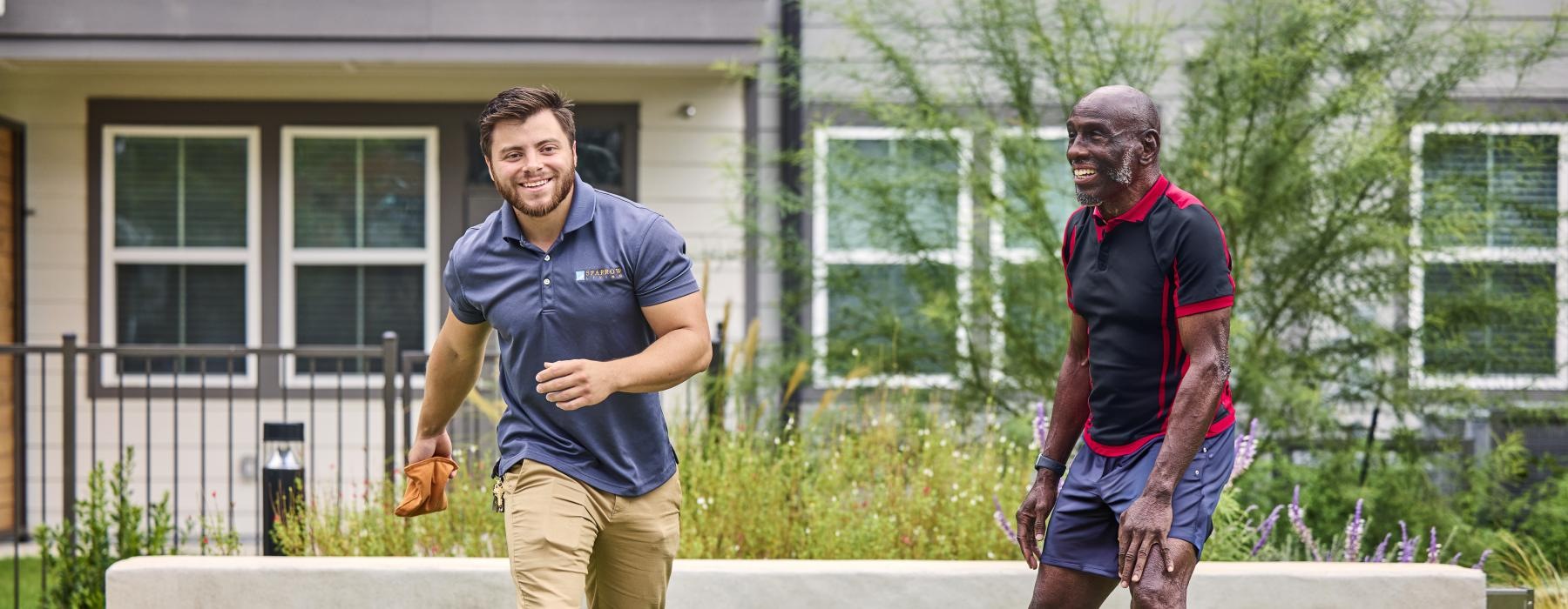 a couple of men playing corn hole