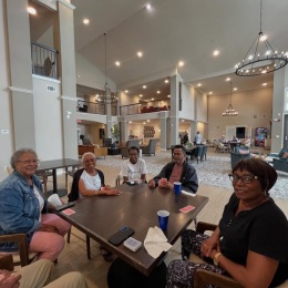 a group of friends playing cards around a table