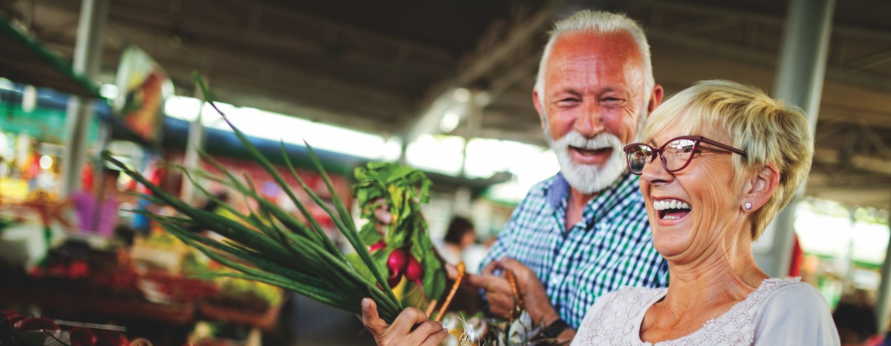 a man and woman holding a basket of vegetables